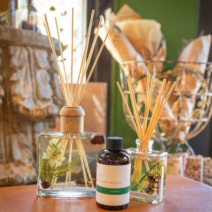 Large and Small Rosy Rings Forest Scented Reed Diffuser displayed next to Diffuser Refill Bottle